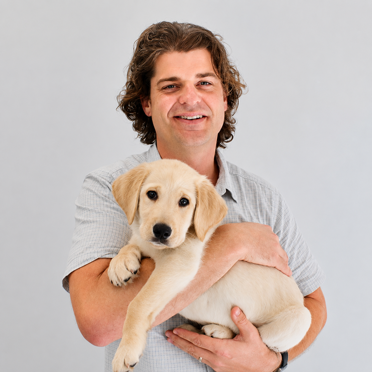 Dr. Brian Hare holding a golden retriever puppy